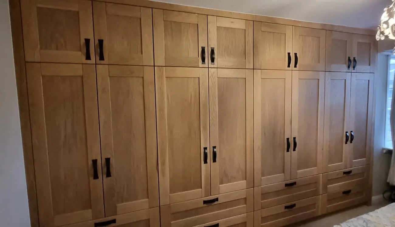 Bespoke solid oak fitted wardrobe with shaker doors and black steel handles, handcrafted by JS DECO