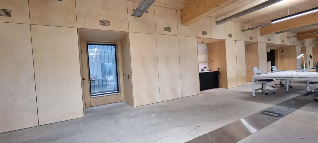 The continuous plywood elevation brings several office functions into one fitted system.