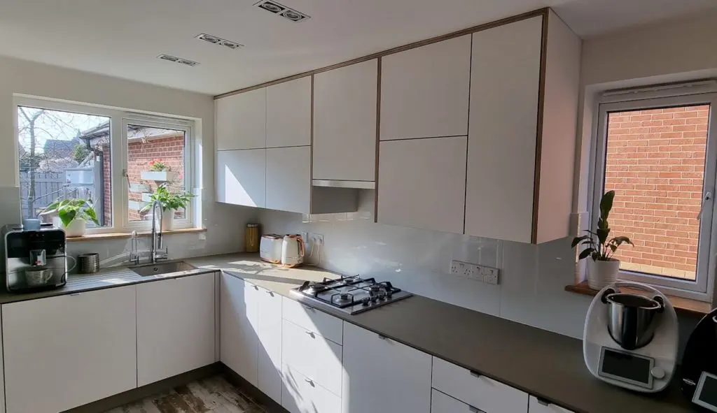 White FENIX NTM kitchen built on a plywood core with exposed edges and minimalist cabinetry, bespoke design by JS DECO.