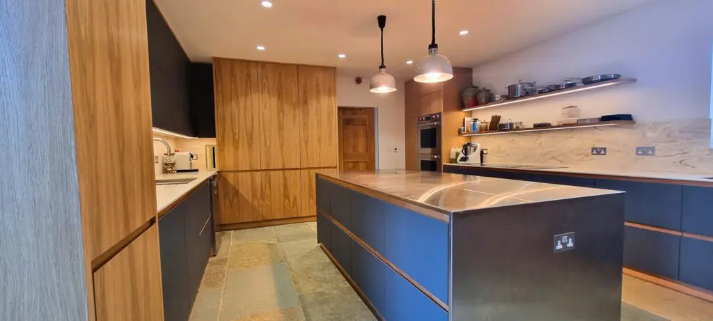Oak grain, matt FENIX fronts and stainless steel seen across the room