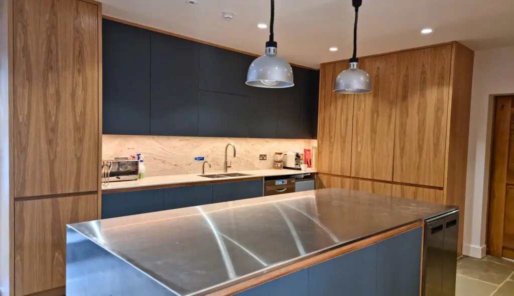 The stainless-steel island faces the sink-side run of cabinetry