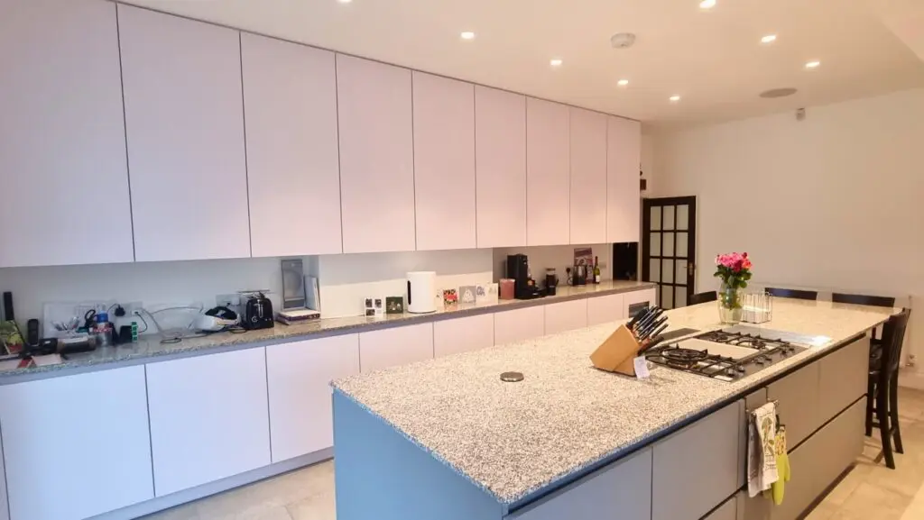 The grey island and white wall cabinets, with cooking and seating at opposite ends.