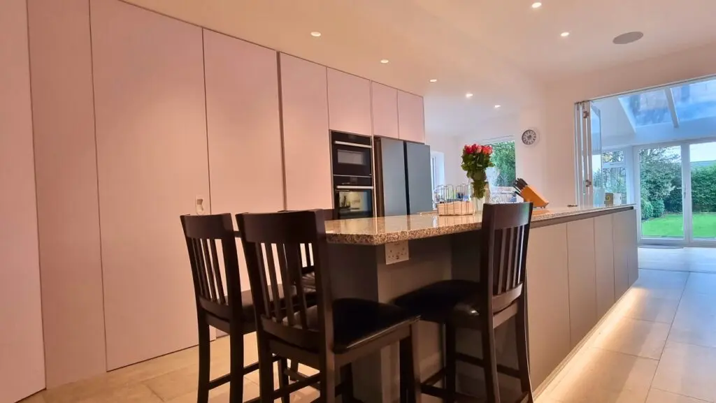 Island seating beside the tall white cabinet elevation.