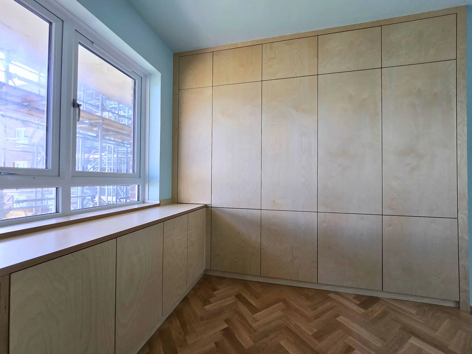 Birch ply wardrobes with grain-matched panels and satin lacquer finish showing natural wood character UK