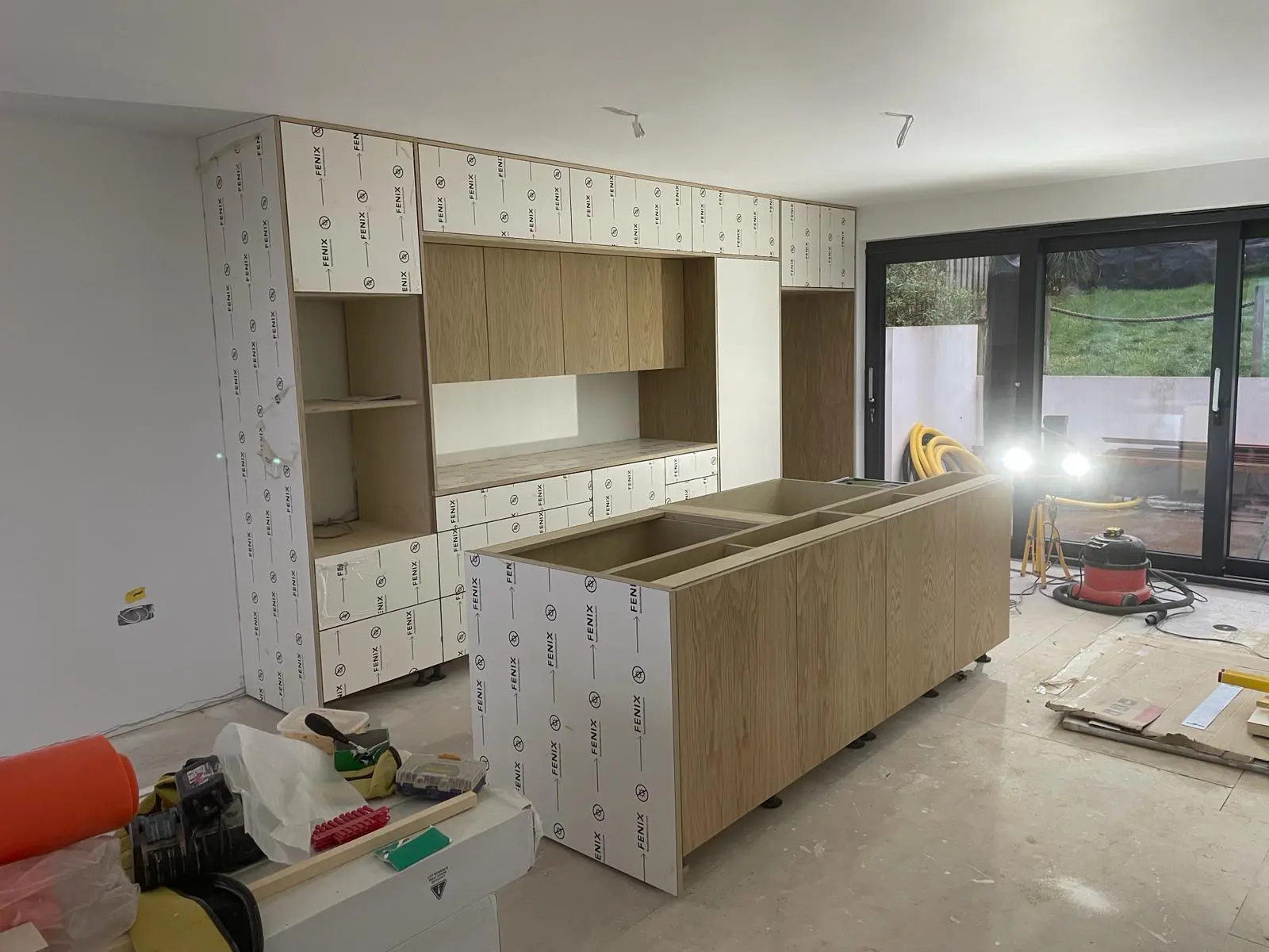 Scandinavian kitchen installation showing handleless oak veneer cabinets and island during fitting Bristol