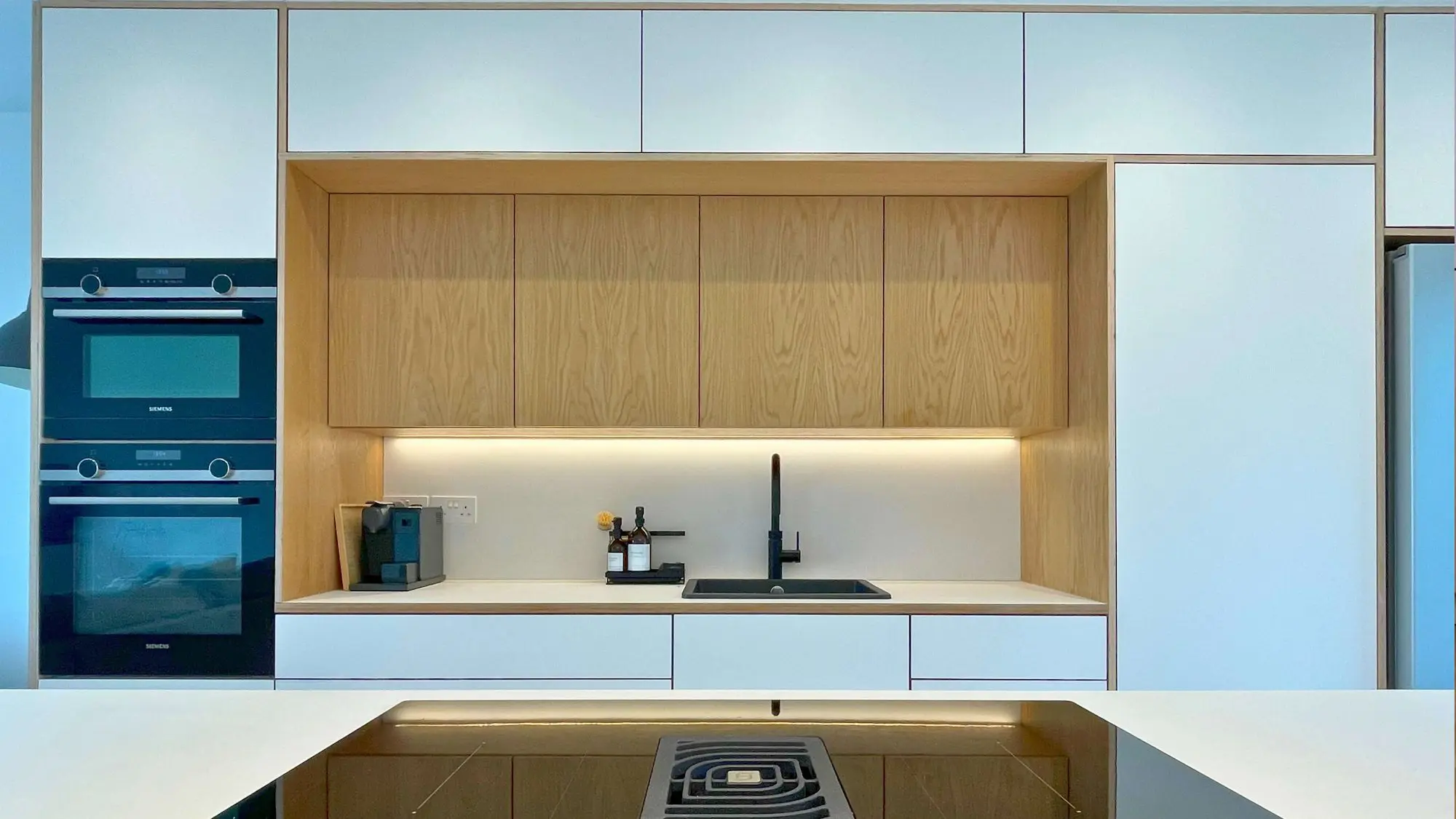 Bespoke Scandinavian kitchen with island featuring oak veneer and white Fenix cabinets Bristol by JS DECO