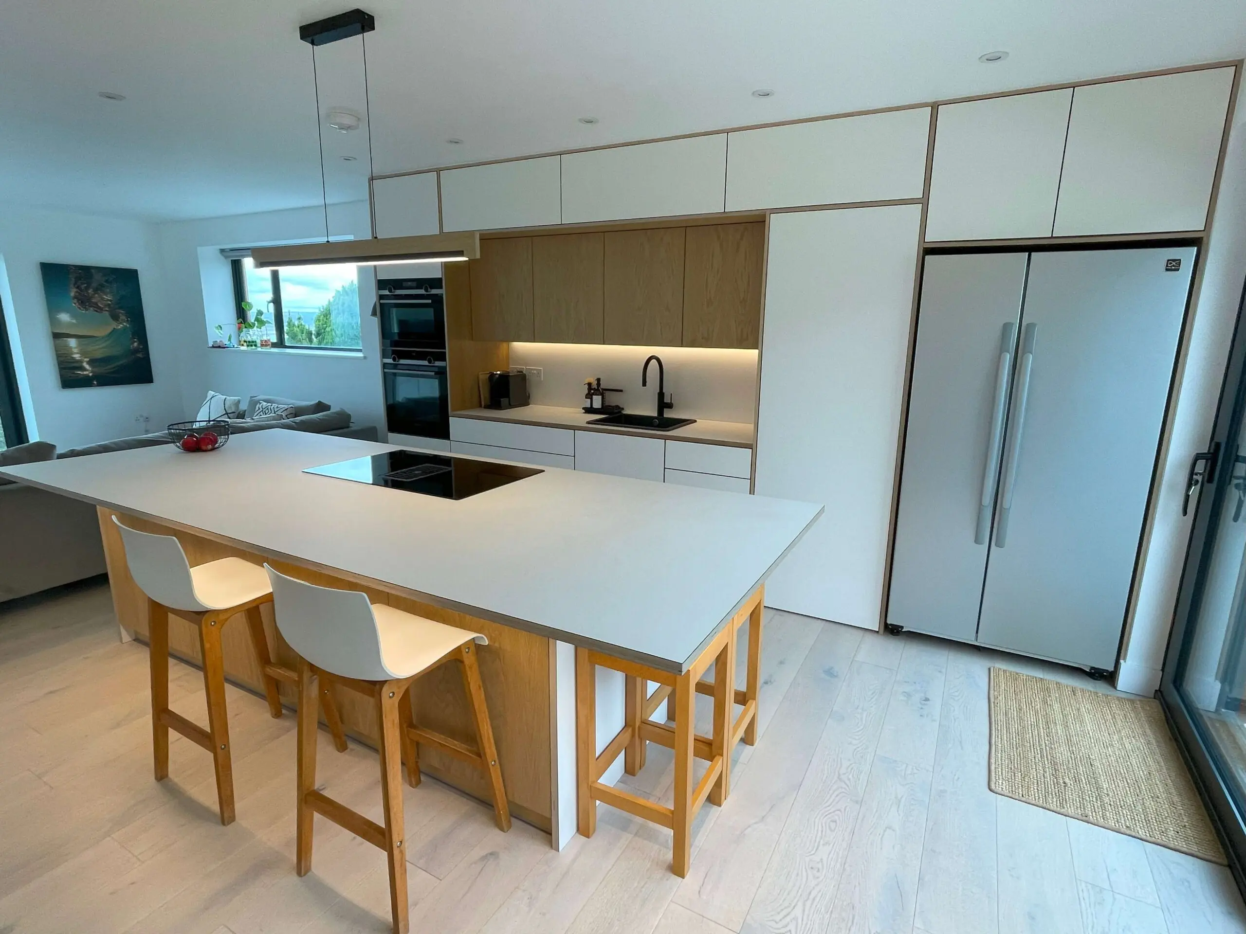 Kitchen with island and seating area in Scandinavian style with oak veneer cabinets Bristol by JS DECO