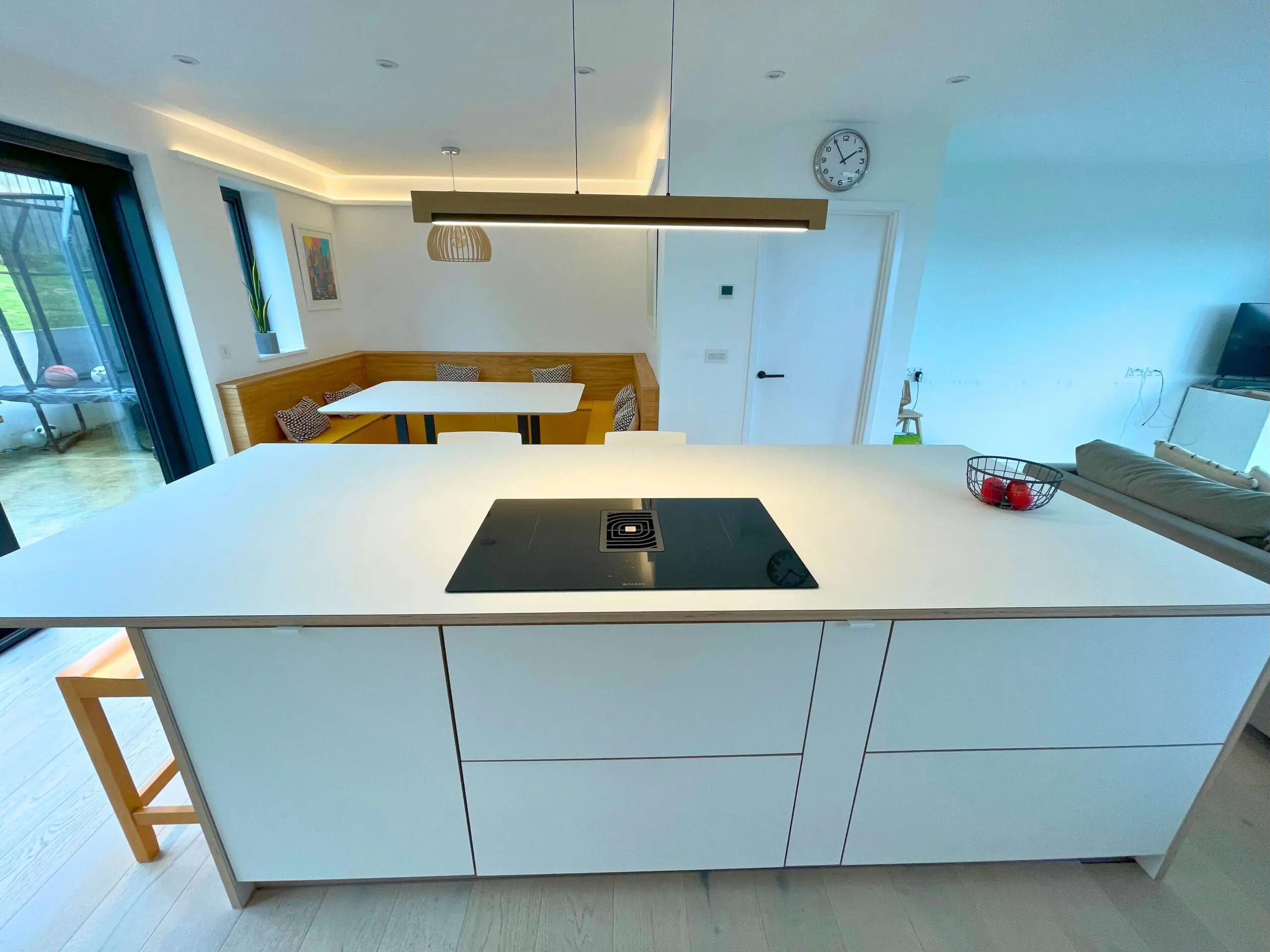 Minimalist kitchen island with induction cooktop and white Fenix handleless cabinets Bristol JS DECO