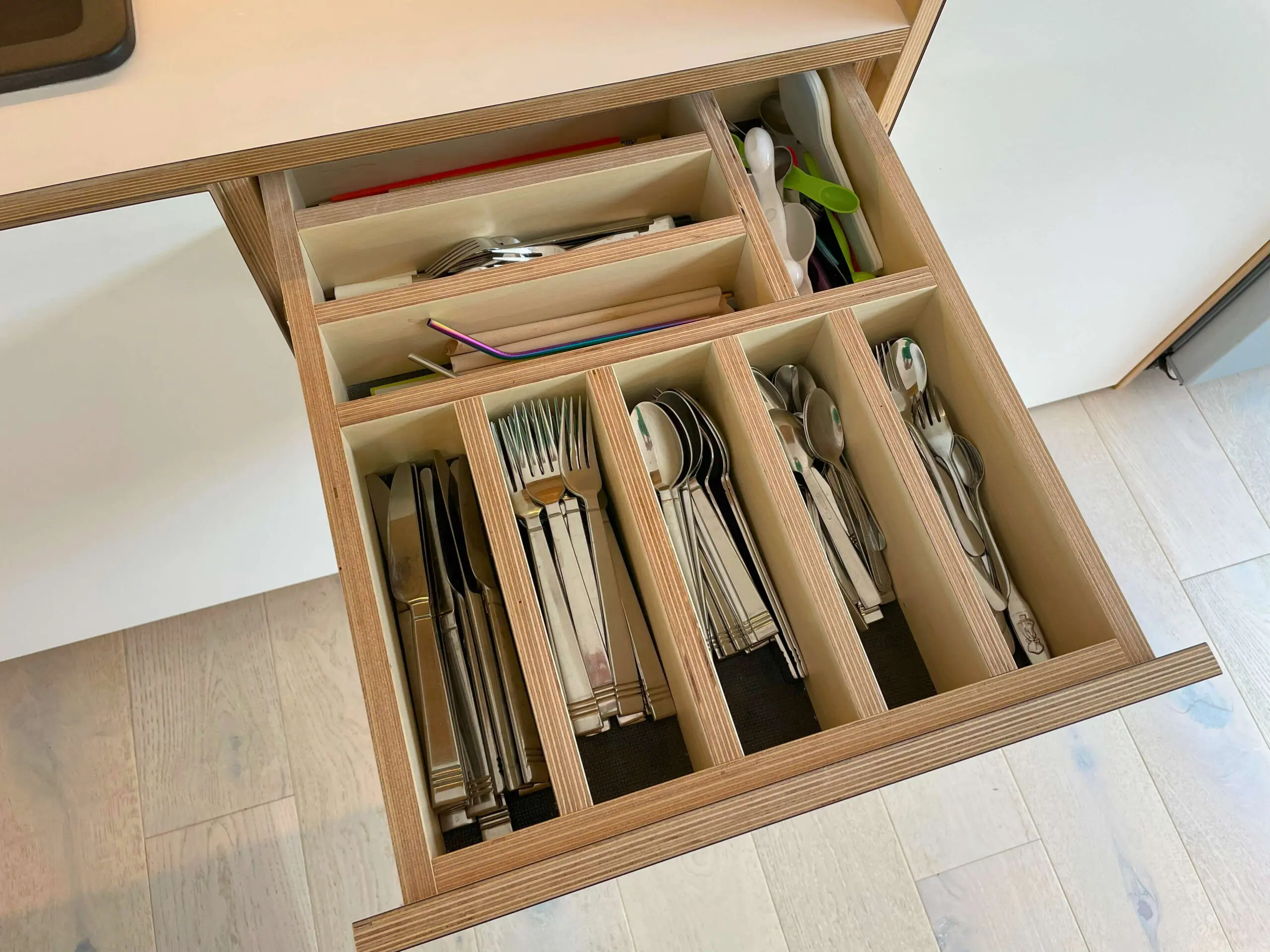 Kitchen cutlery drawer with oak wood inserts and custom organization in Scandinavian kitchen Bristol