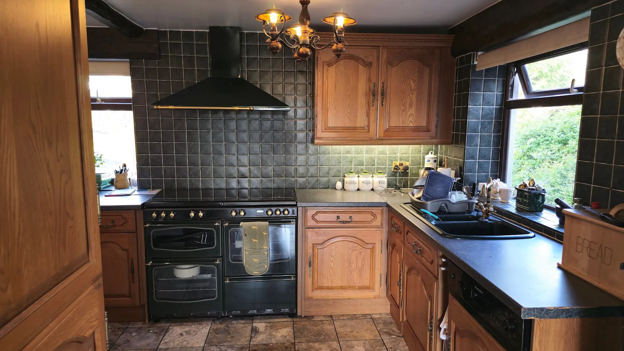 Old oak kitchen before renovation in Huddersfield showing dated cabinets and dark tile backsplash