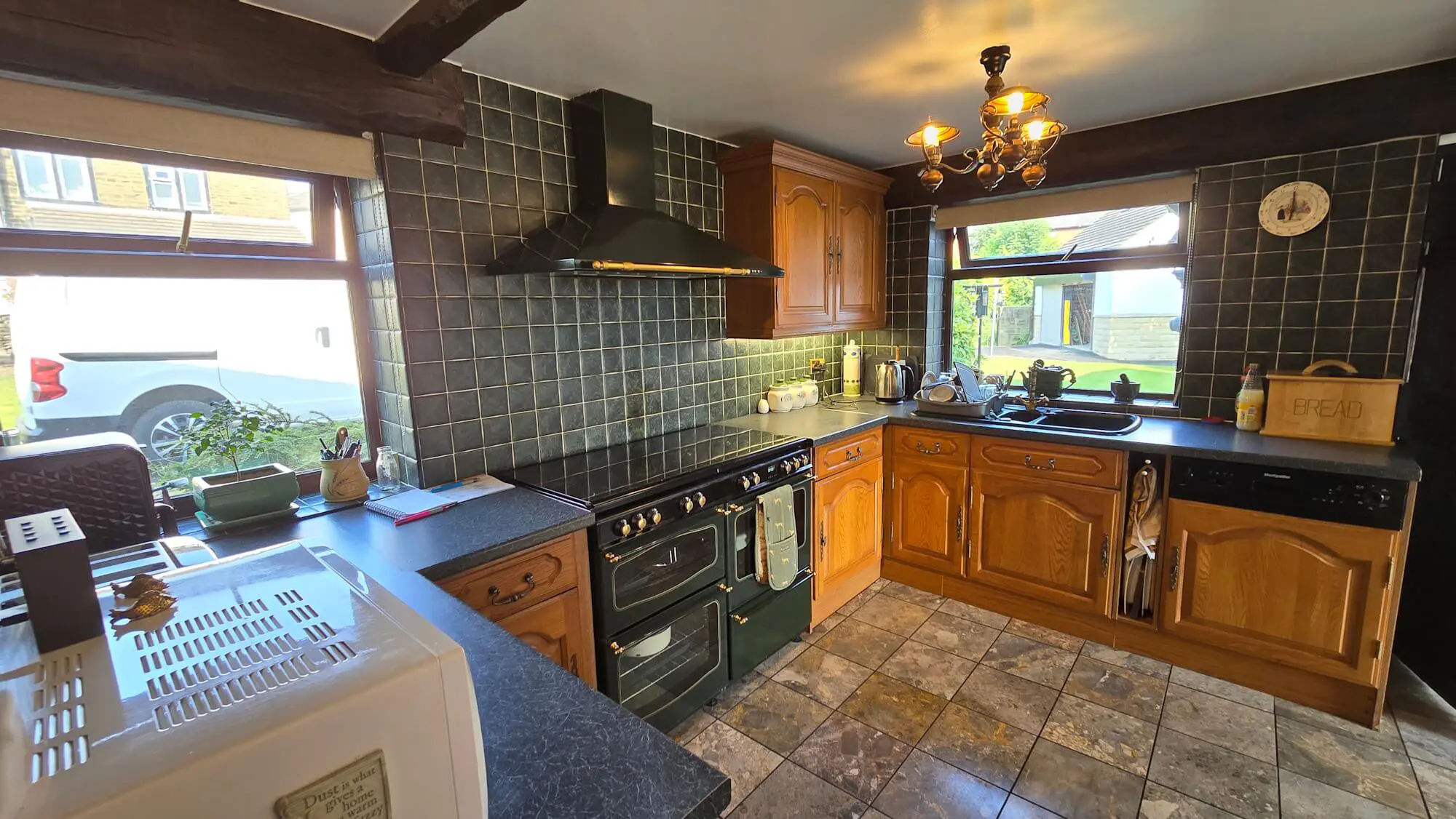 Kitchen layout before hand made oak renovation showing dated cathedral doors and stone flooring