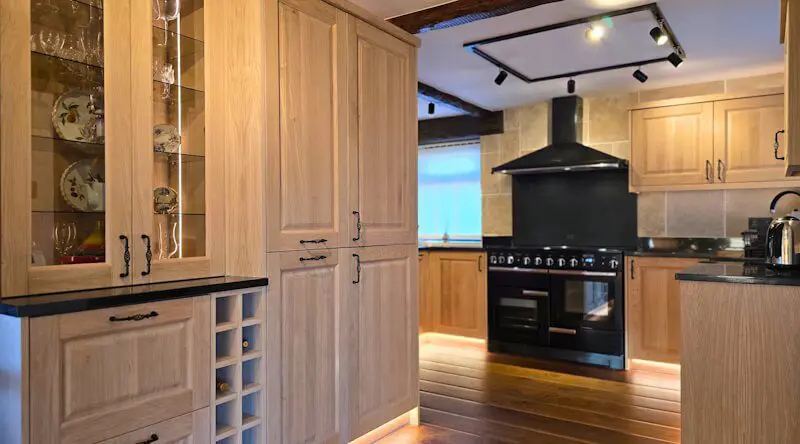 Bespoke plywood kitchen with oak-style fronts and black range cooker, handmade by JS DECO furniture studio in the UK.