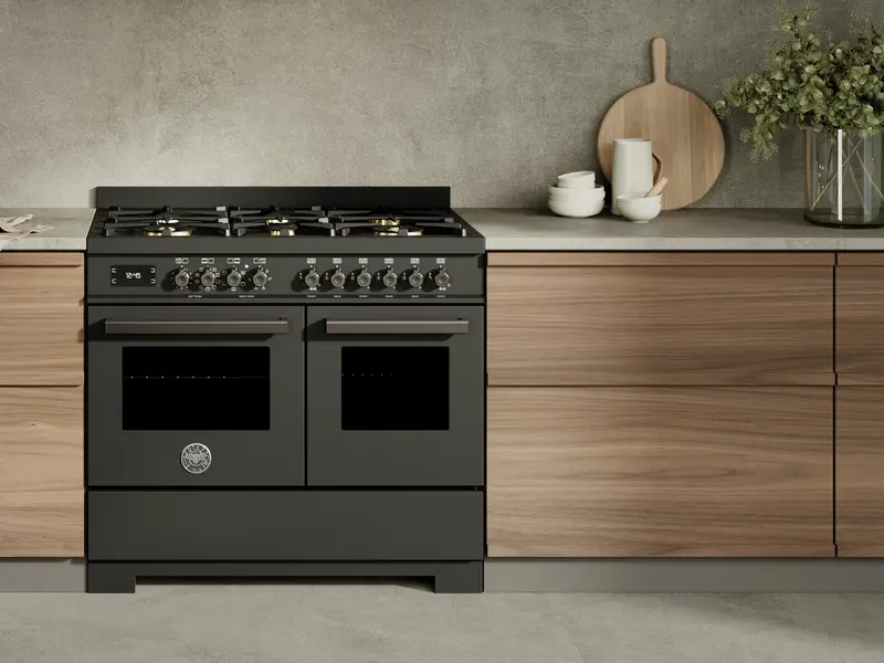 Close view of a dark Bertazzoni range cooker with twin oven doors and gas burners