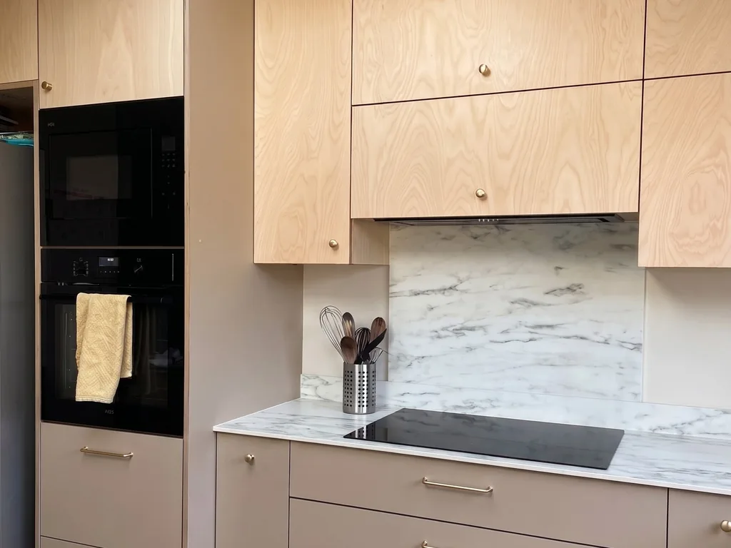 Mid-century style bespoke kitchen with natural plywood fronts, taupe cabinetry and brass details