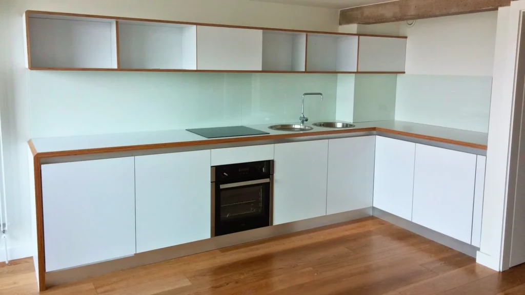 Modern industrial kitchen detail with plywood worktop white handleless units and stainless steel sink in Park Hill Sheffield