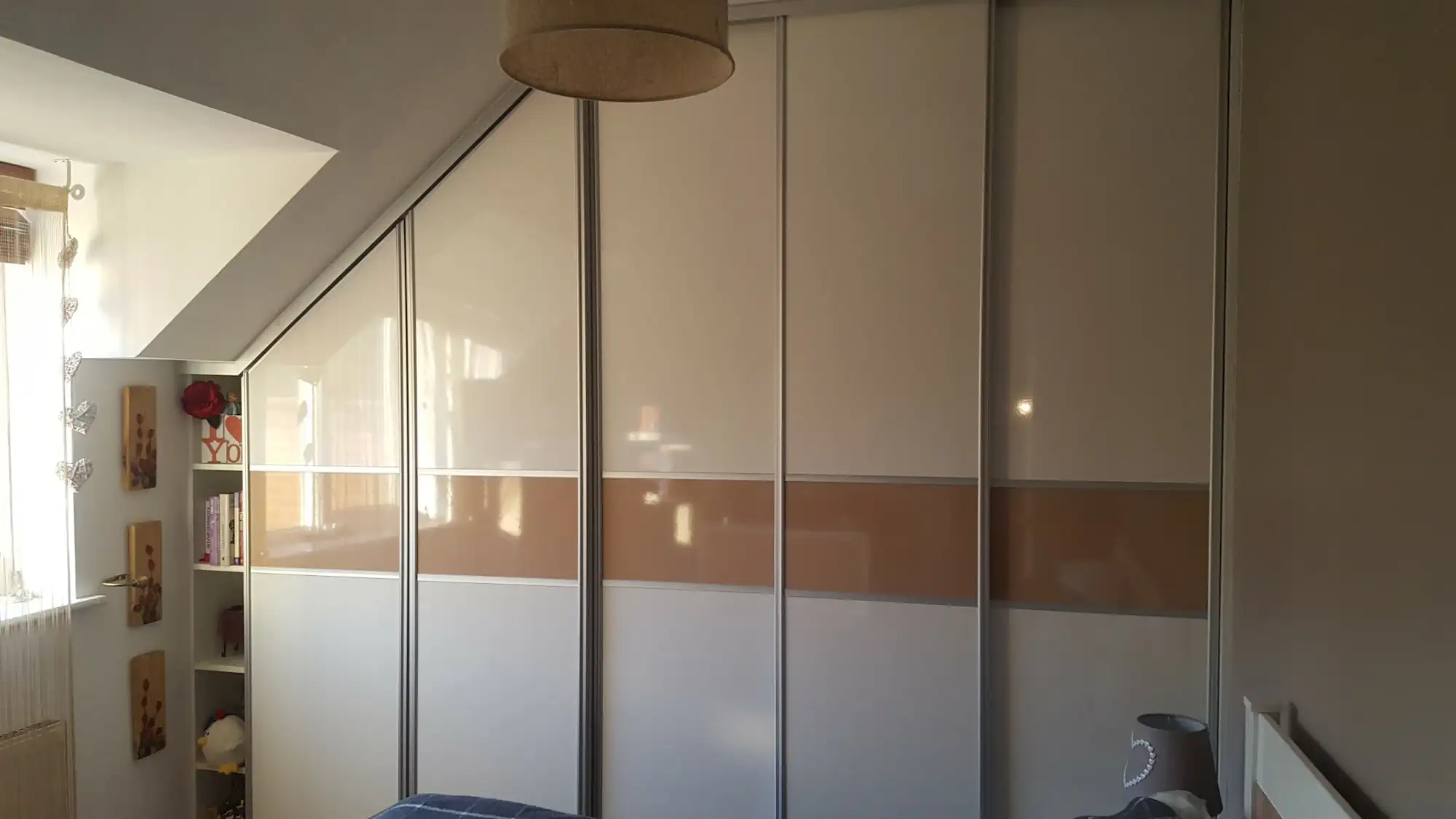 Sliding door wardrobe under slopped ceiling Sliding doors white and beige wardrobe fitted under sloped ceiling.