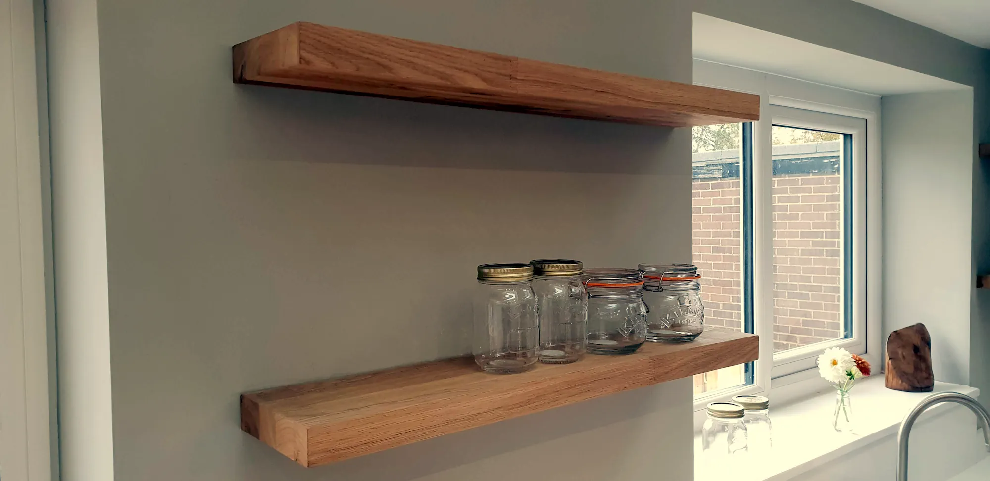Floating shelves next to the window i the kitchen extension