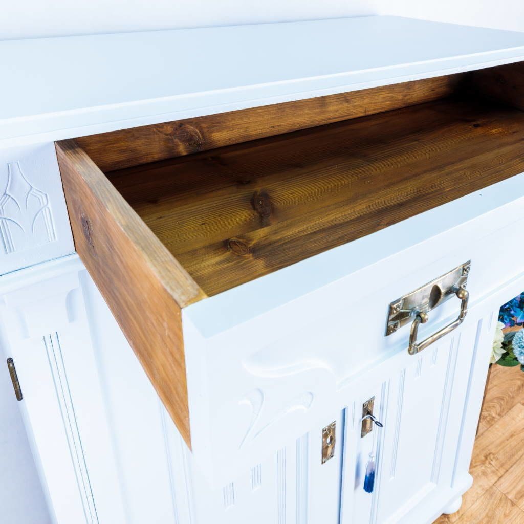 White cabinet with open wooden drawer