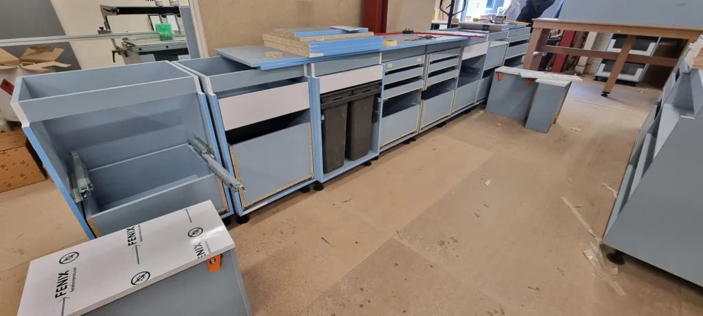 Workshop assembly: pull-out bin storage and drawer hardware.