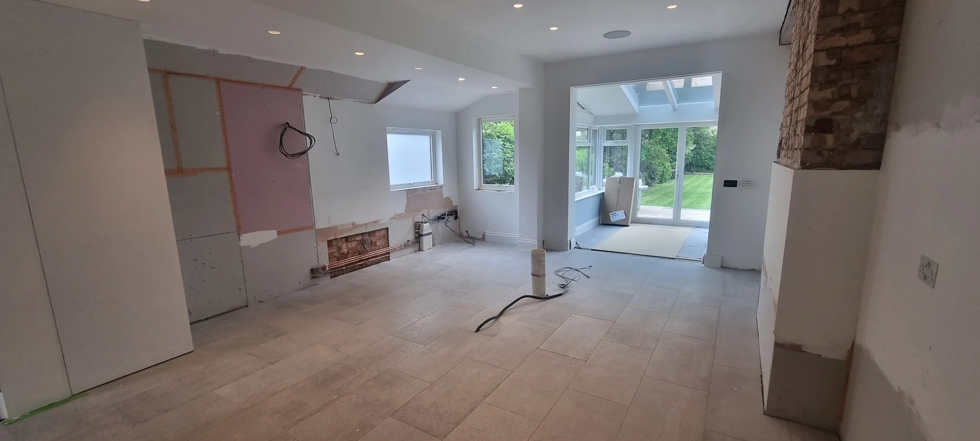 Before installation stage of large white and grey FENIX NTM bespoke kitchen London exposed brick and unfinished walls