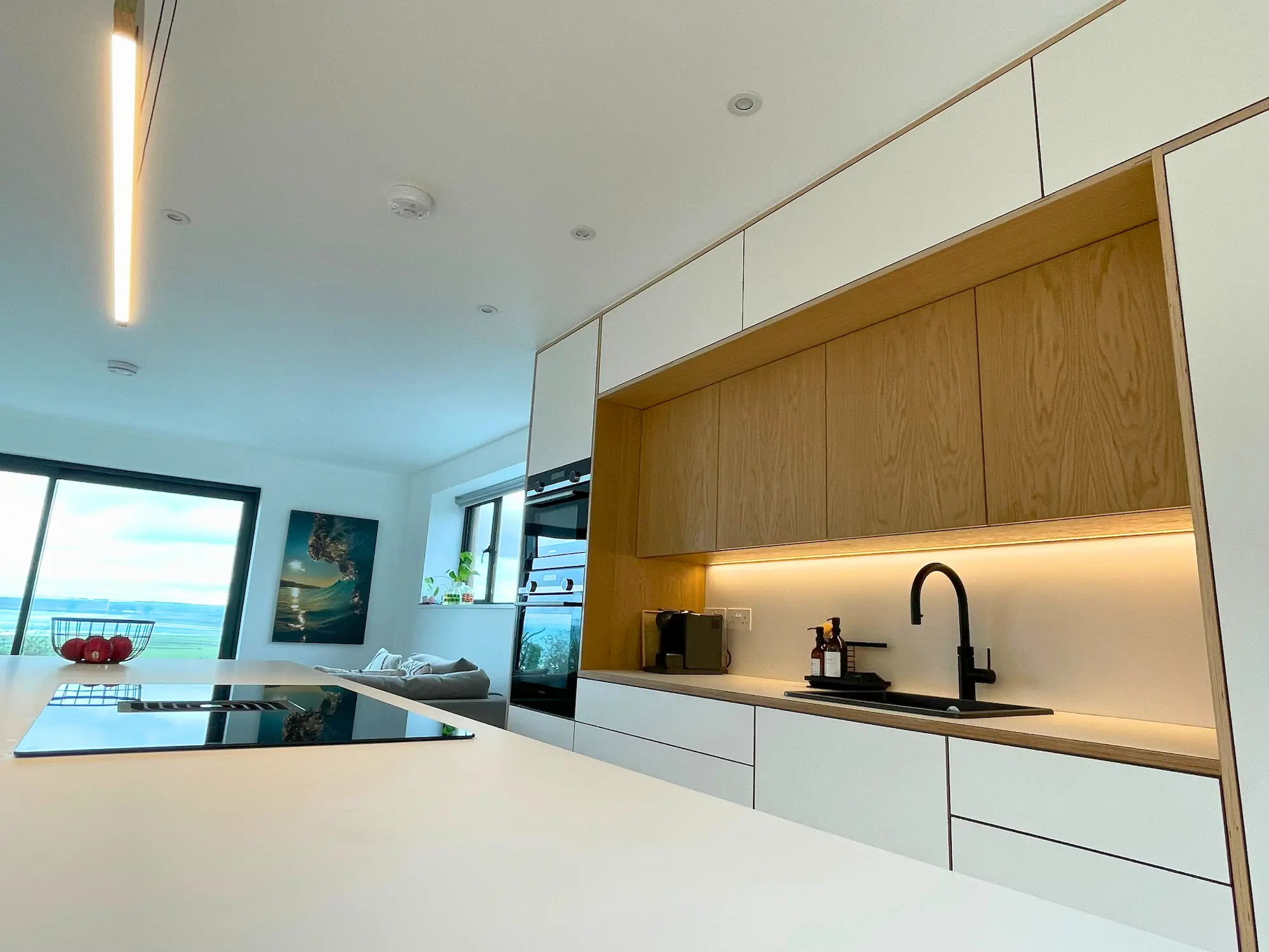 Modern plywood kitchen in London with oak cabinet fronts, white birch plywood units and integrated lighting by JS DECO.