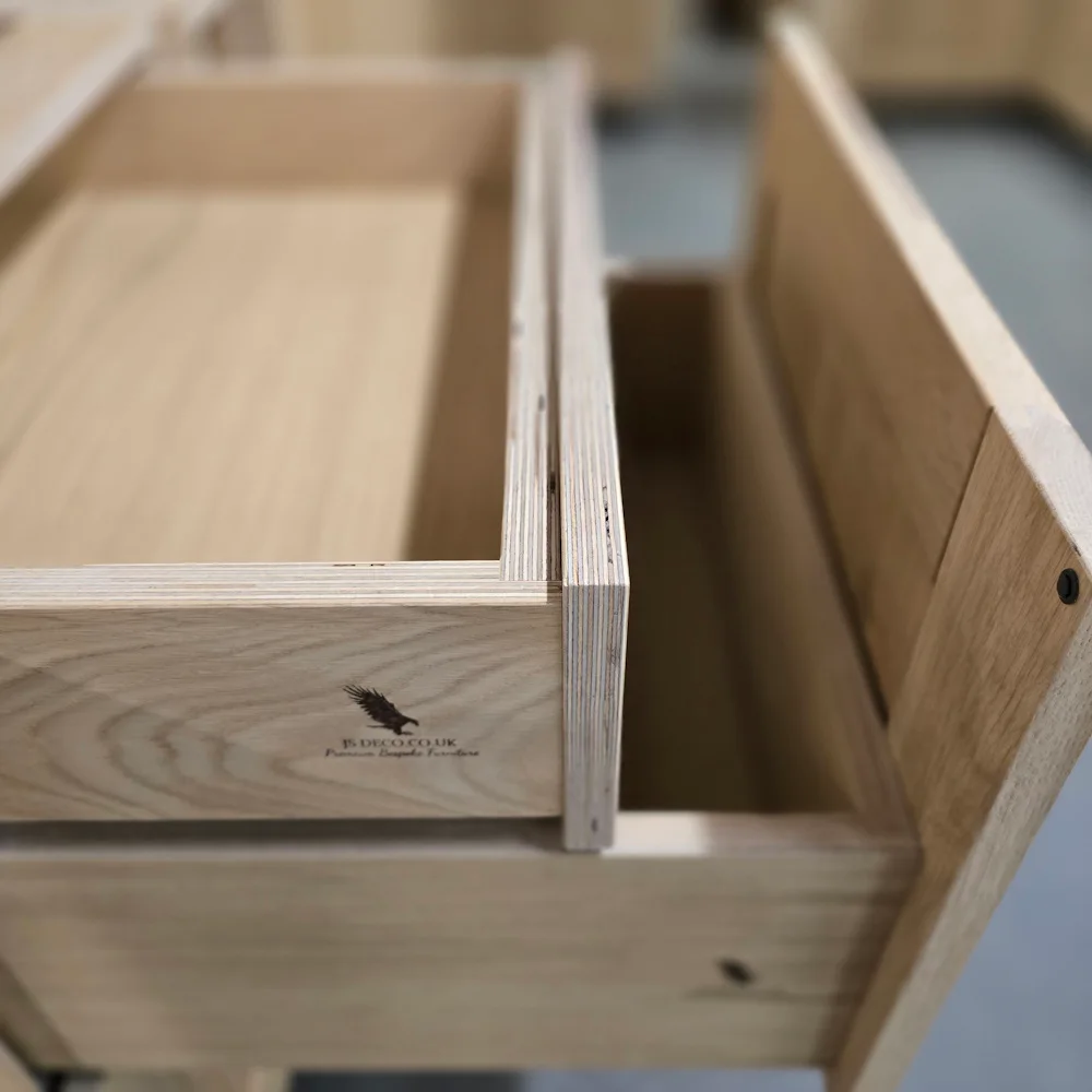 Close-up of hand-crafted solid oak kitchen drawer with dovetail joints and natural finish
