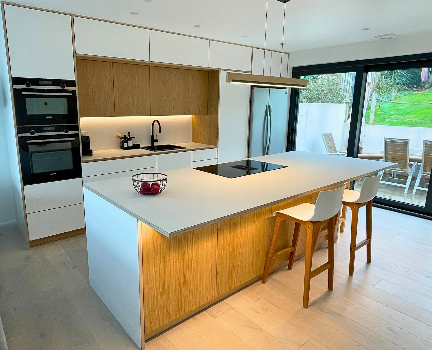 Birch plywood kitchen furniture with grain-matched doors and extra-tall cabinets by JS DECO.
