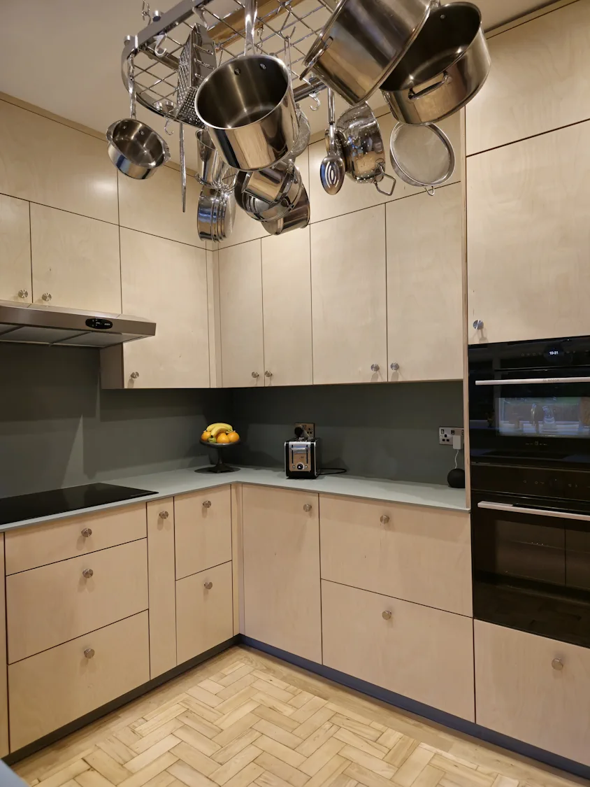 Bespoke plywood kitchen with green FENIX worktops in Matlock Bespoke plywood kitchen with green FENIX worktops and pot rack in renovated Matlock Derbyshire property