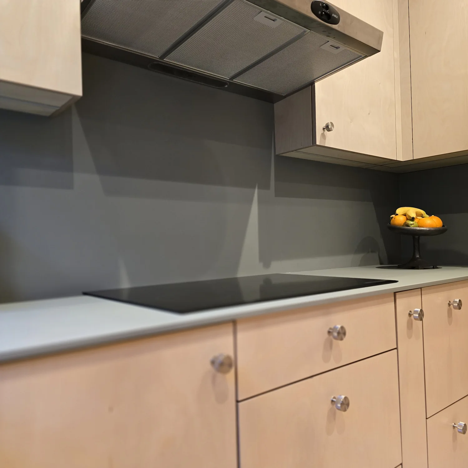 Plywood kitchen hob with integrated extractor in Matlock Plywood kitchen hob area with induction cooktop and integrated extractor housing with green splashback in Matlock Derbyshire