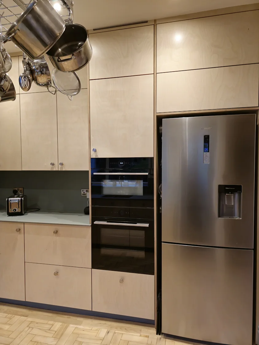 Modern plywood U-shaped kitchen with fridge freezer in Matlock Modern plywood U shaped kitchen with tall oven housing and stainless steel fridge freezer in Matlock Derbyshire
