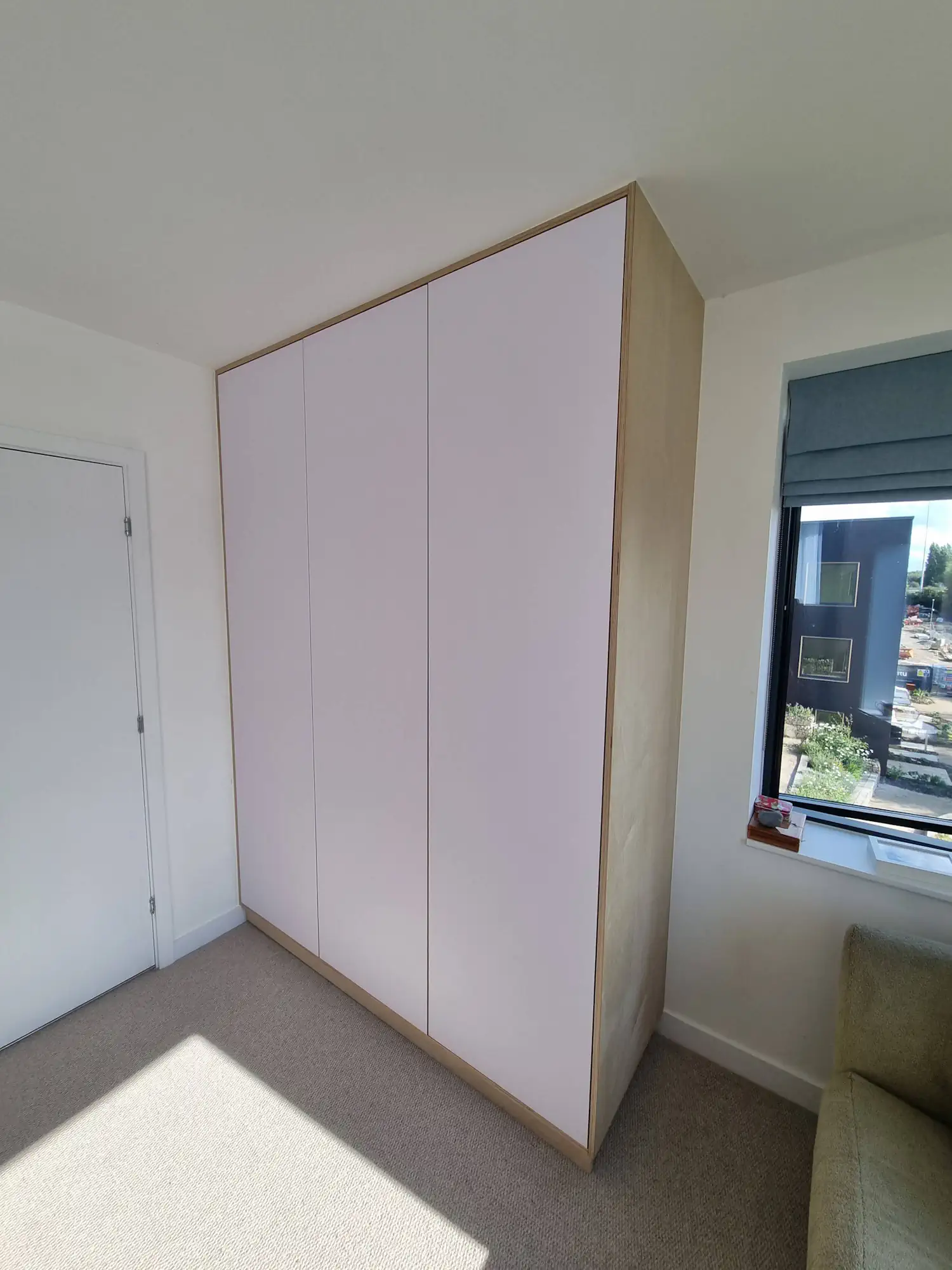 Modern plywood finished with white FENIX NTM laminate wardrobe in minimalistic room
