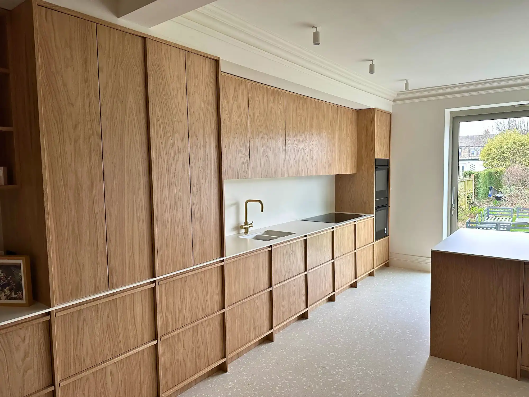 Main working run with integrated appliances Oak veneered kitchen cabinets with sink, hob and oven housing in Leeds