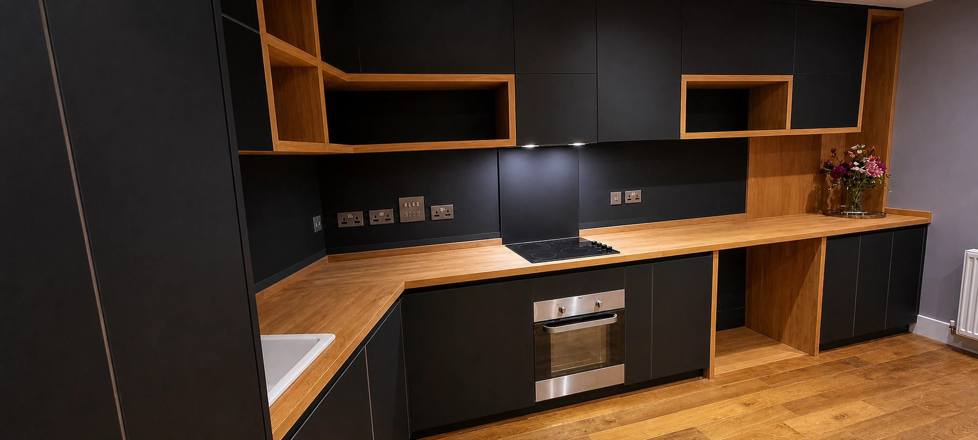 Lambarde Square 120-degree kitchen layout Bespoke Lambarde Square kitchen showing the angled oak worktop, dark cabinetry and integrated oven