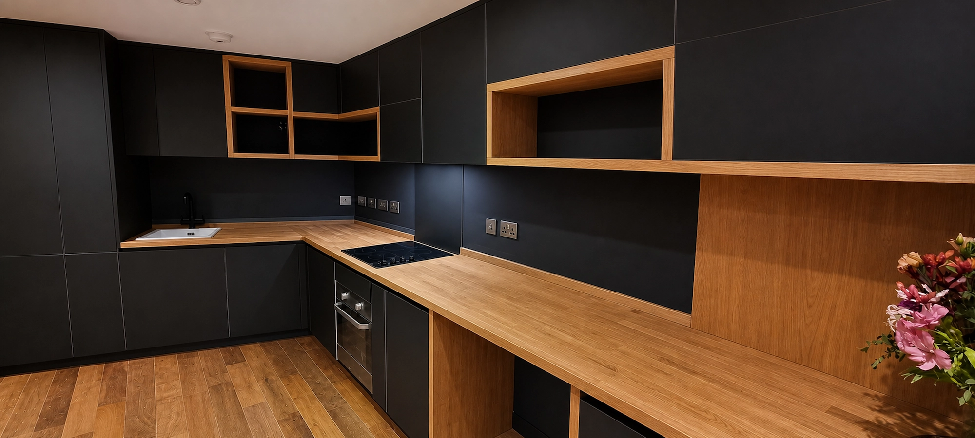 Lambarde Square FENIX and solid oak detail Solid oak worktop with FENIX kitchen cabinets, hob and open oak shelving at Lambarde Square