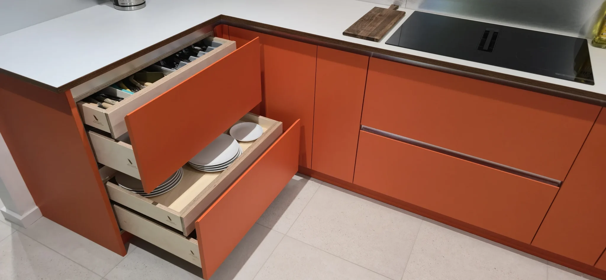 Open plywood drawers with the cutlery tray and plate storage visible.