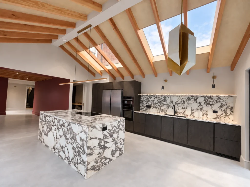 The ceramic island faces the dark oak cabinet run in the completed extension.