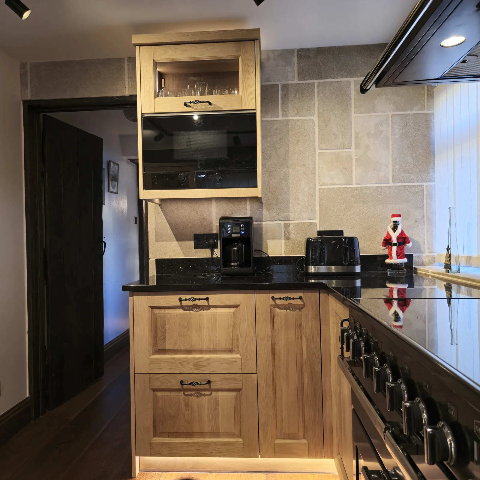 JS DECO timber kitchen cabinetry around a black built-in appliance and range cooker