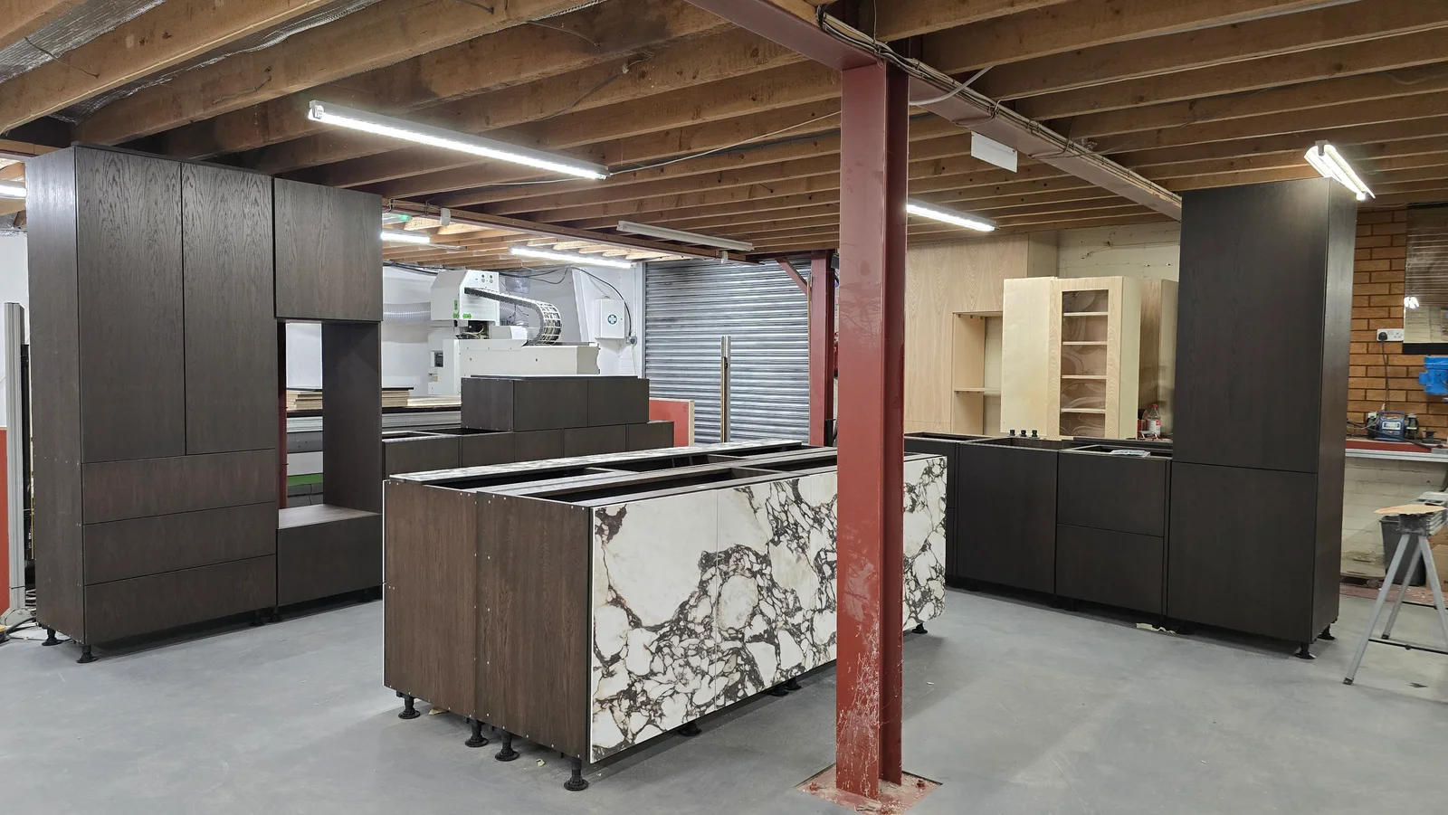 Bespoke dark timber cabinetry and patterned island panels assembled in the JS DECO workshop