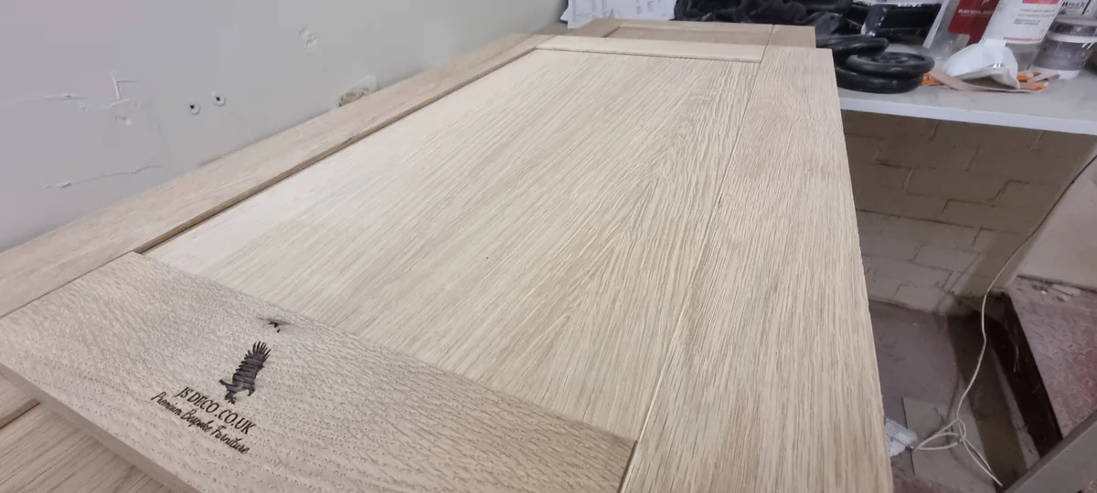 Close-up of the grain and frame of a JS DECO branded timber cabinet door